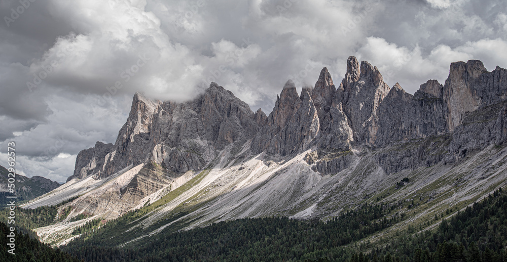 Odle mountain massif, Puez-Odle nature park, Dolomites, Italy-August 20, 2015: Hikers crossing Brogles pass on the way from Brogles refuge back to Ortisei village in Gardena valley