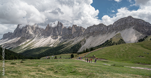 Odle mountain massif, Puez-Odle nature park, Dolomites, Italy-August 20, 2015: Hikers crossing Brogles pass on the way from Brogles refuge back to Ortisei village in Gardena valley