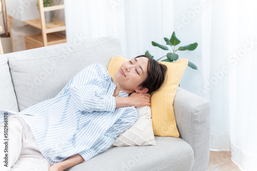 ソファーで寝るミドル女性（睡眠・健康・ヘルスケア）