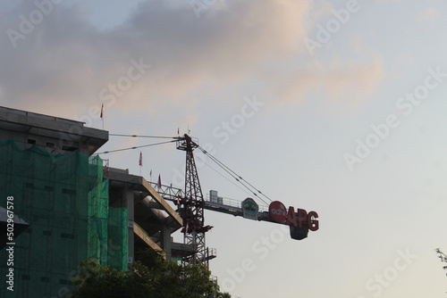 A very tall crane used for construction work against a cloudy sky background