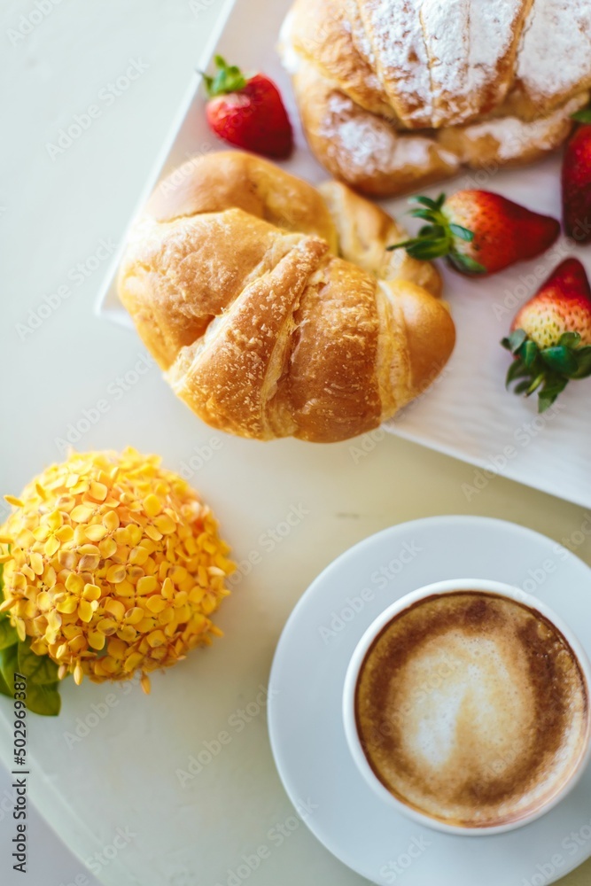 Fresh croissant with coffee and flowers. Flatlay breakfast Fresh croissant with coffee and flowers. Flatlay breakfast