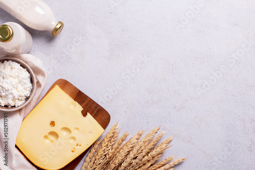Shavuot background with dairy products and wheat on light gray background, web banner