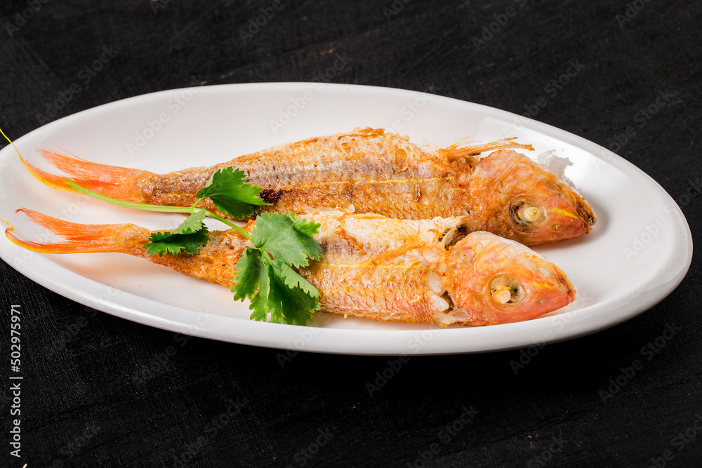 A plate of fried red shirted fish A plate of fried red shirted fish