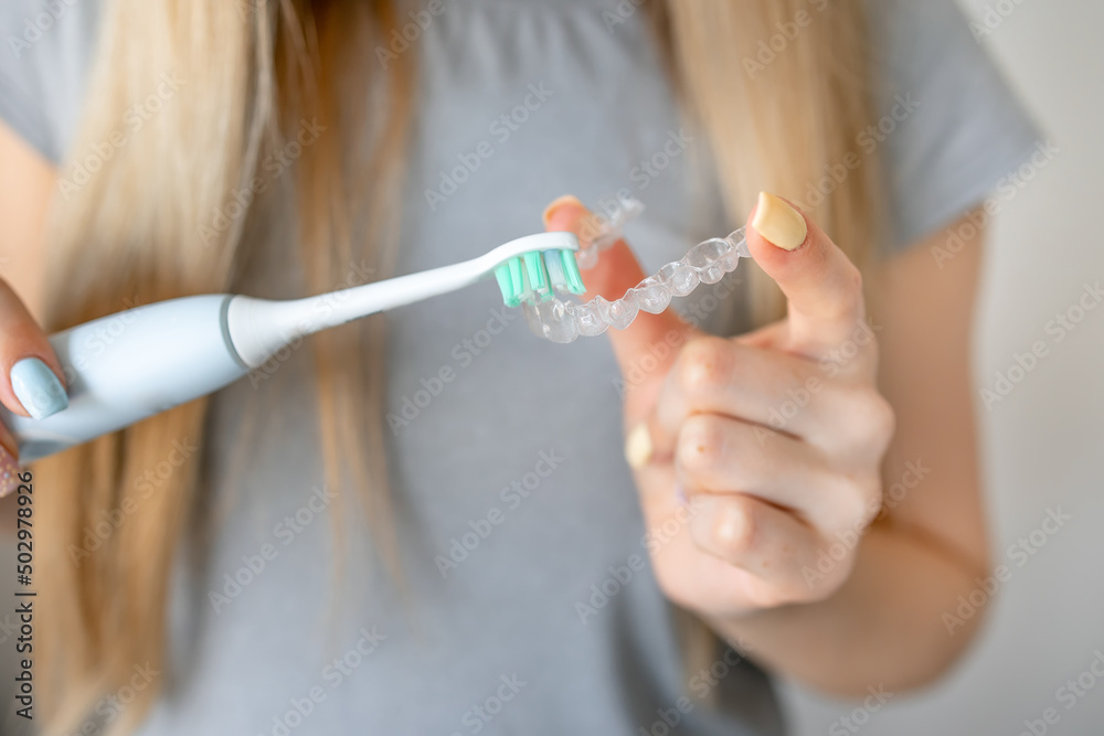 Cleaning tooth aligners. Washing and removing organic residues with using toothbrush from orthodontic invisible braces. Cleaning tooth aligners. Washing and removing organic residues with using toothbrush from orthodontic invisible braces.