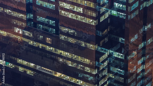 Fotografia Windows in office building exterior in the late evening with interior lights on