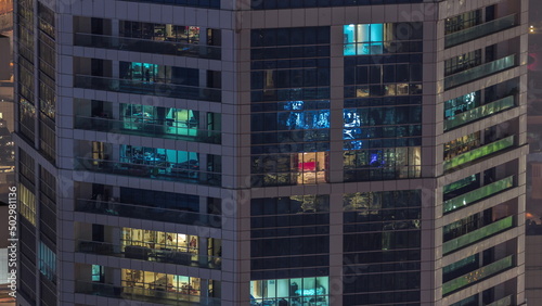 Windows in high-rise building exterior in the late evening with interior lights on timelapse © neiezhmakov