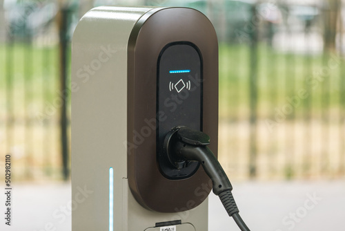 Une station de charge pour voiture électrique en ville. Le connecteur est inséré et le fil de rechargement est branché. photo