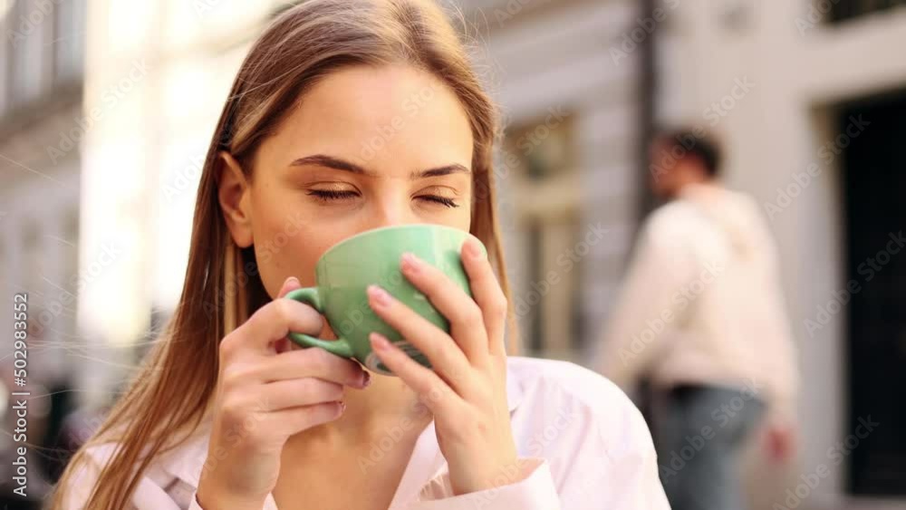 Portrait of satisfied woman drinking coffee in the cafe. Attractive lady enjoying cup of coffee at the city centre. Morning. Portrait of satisfied woman drinking coffee in the cafe. Attractive lady enjoying cup of coffee at the city centre. Morning.