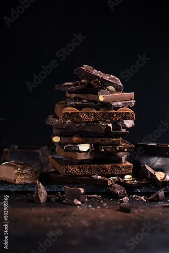 Bar of Chocolate tower pieces. Hazelnut and almond dark chunks of broken chocolate. Sweet food photo concept.