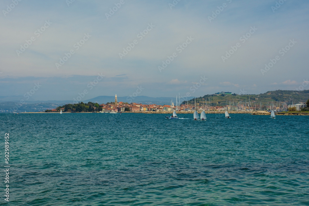 The historic town of Izola on the Adriatic coast of Slovenia. A sailing school practices in the foreground right
