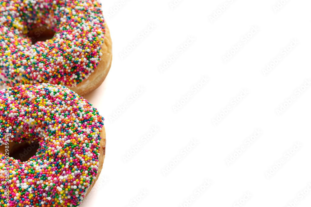 Donuts with colorful sprinkles isolated on white background. High angle view with copy space for text. Donuts with colorful sprinkles isolated on white background. High angle view with copy space for text.