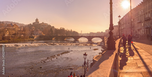 Turin, Italy. February, 15, 2022. View at sunset on the Po river from Lungo Po Luigi Cadorna street. In the distance, the old Vittorio Emanuele I bridge. photo