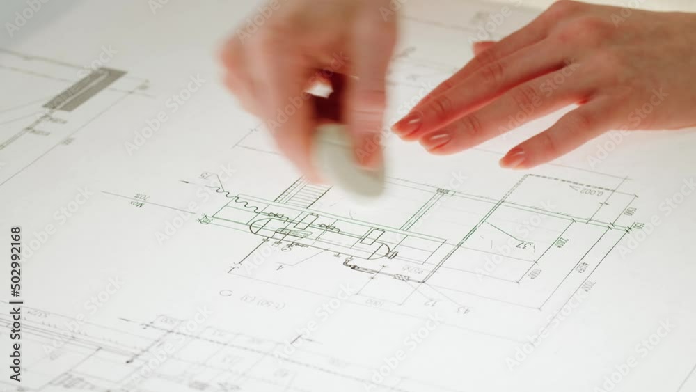Architect designer drawing plan blueprint close-up, using eraser. Professional engineer working, interior creator making architectural house project, drafting building. Architect designer drawing plan blueprint close-up, using eraser. Professional engineer working, interior creator making architectural house project, drafting building.
