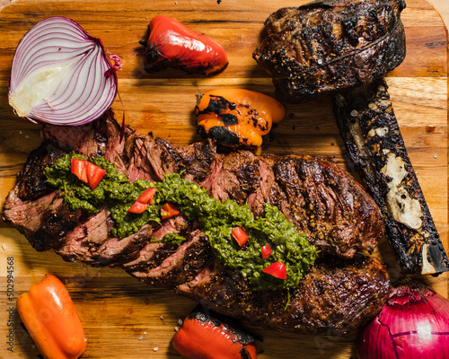 Grilled steak and cowboy rib with vegetables and chimichurri sauce