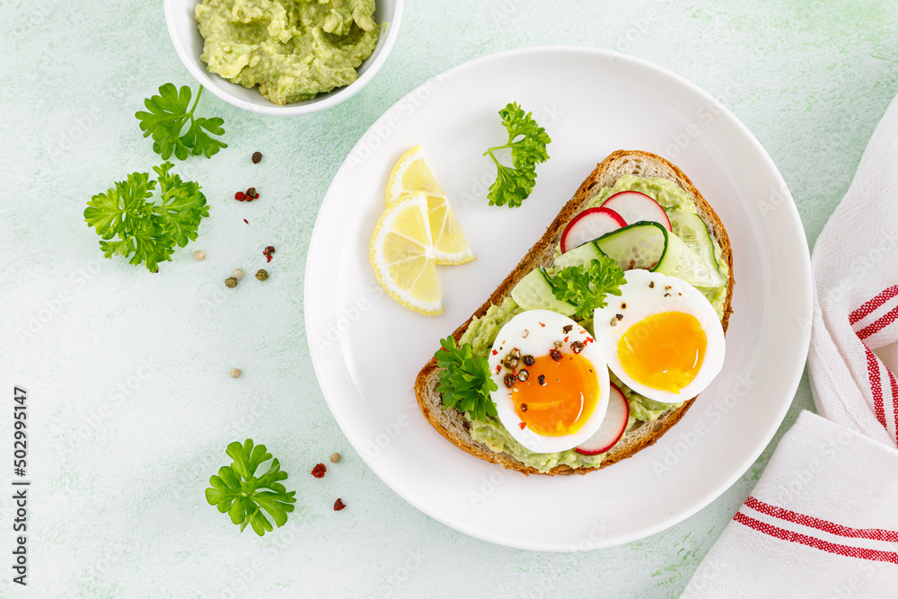 Toast with boiled egg, radish, cucumber and avocado pate. Top view Toast with boiled egg, radish, cucumber and avocado pate. Top view