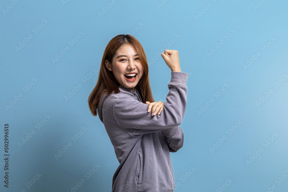 Portrait of beautiful Asian woman doing cheerful pose on isolated background, portrait concept used for advertisement and signage, isolated over blue background, copy space. Portrait of beautiful Asian woman doing cheerful pose on isolated background, portrait concept used for advertisement and signage, isolated over blue background, copy space.