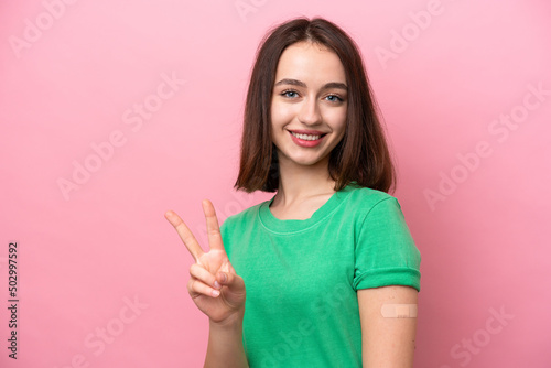 Young Ukrainian woman wearing a band aids smiling and showing victory sign © luismolinero