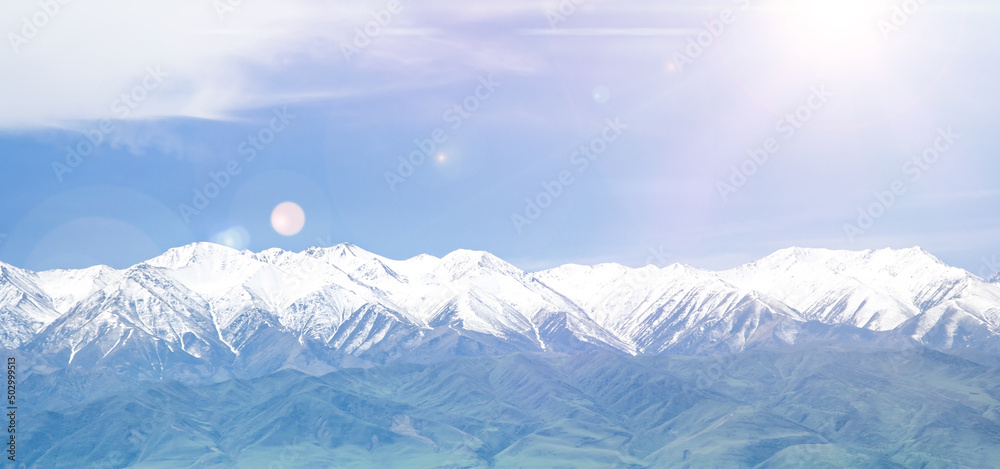 snowy mountains background with clouds and sun rays