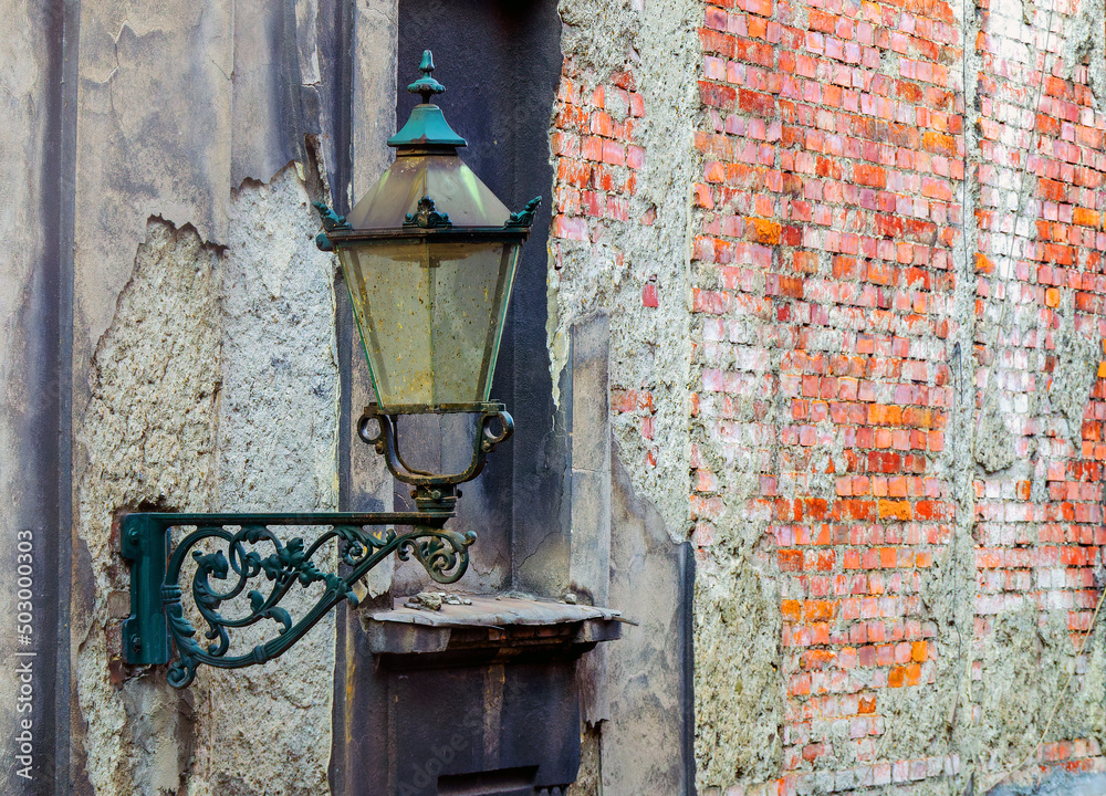 an old street lamp on the background of a shabby building wall an old street lamp on the background of a shabby building wall