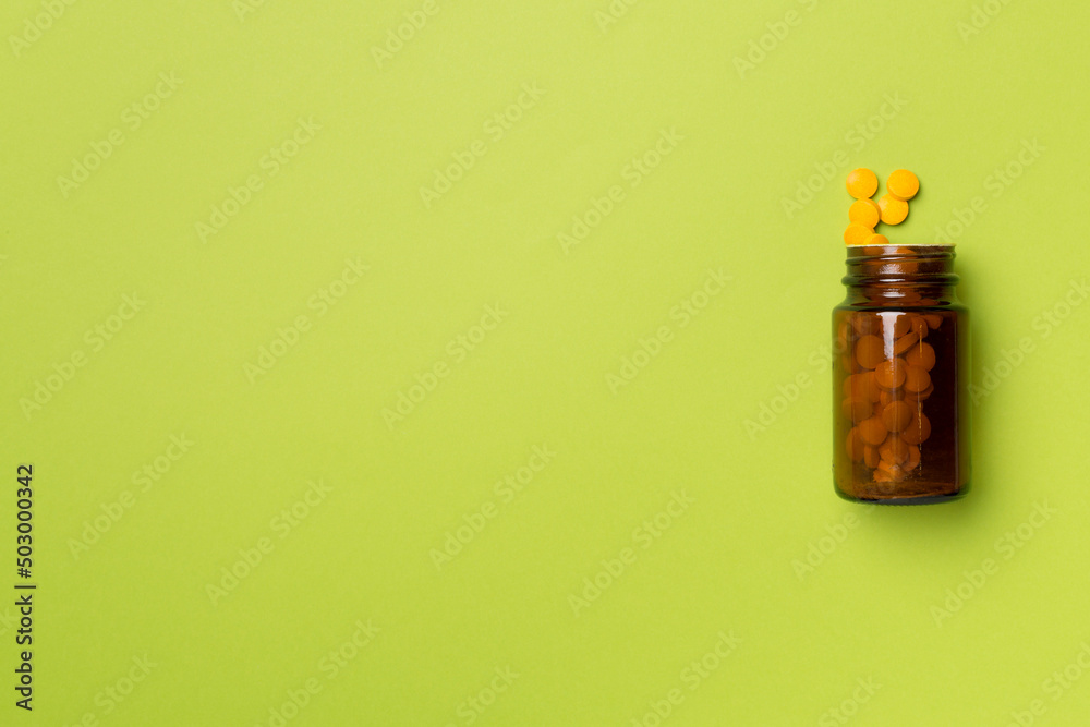 Glass bottle with pills on color background, top view Glass bottle with pills on color background, top view