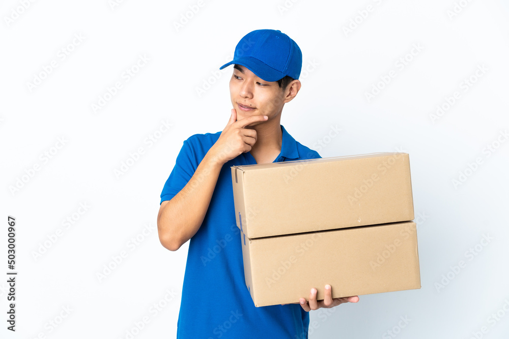 Delivery Chinese man isolated on white background looking to the side and smiling Delivery Chinese man isolated on white background looking to the side and smiling