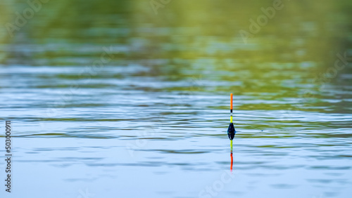 Yellow-orange fishing float on the surface of the water