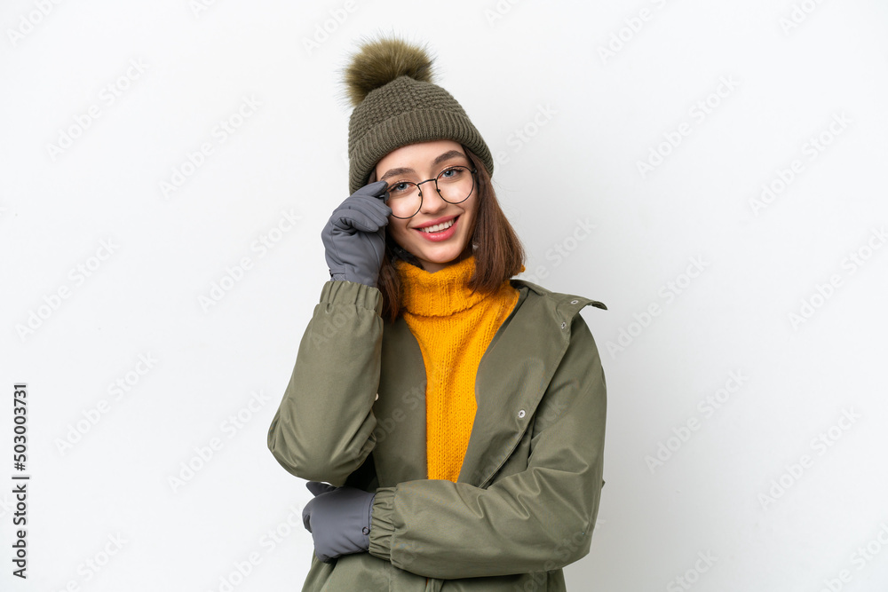 Young Ukrainian woman wearing winter jacket isolated on white background with glasses and happy Young Ukrainian woman wearing winter jacket isolated on white background with glasses and happy