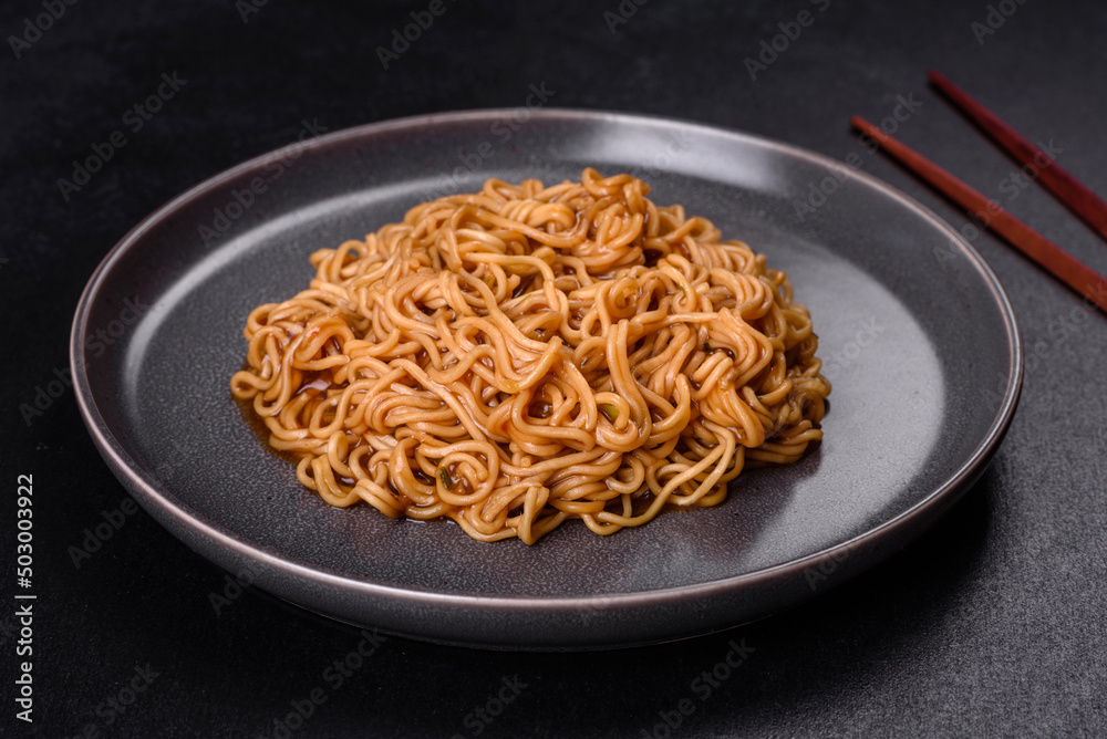 Buckwheat flour noodles with sauce, sesame, herbs and spices on a dark concrete background Buckwheat flour noodles with sauce, sesame, herbs and spices on a dark concrete background