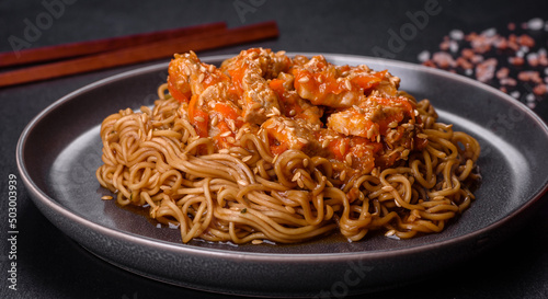 Thai noodle and chicken plate on a black concrete background with Chinese chopsticks and copy space