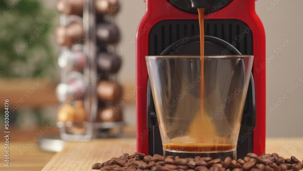 4k video, Automatic coffee machine with black coffee capsules or coffee pods pouring espresso drink in clear glass with hot smoke. Breakfast time with Making Fresh Americano drink. 4k video, Automatic coffee machine with black coffee capsules or coffee pods pouring espresso drink in clear glass with hot smoke. Breakfast time with Making Fresh Americano drink.