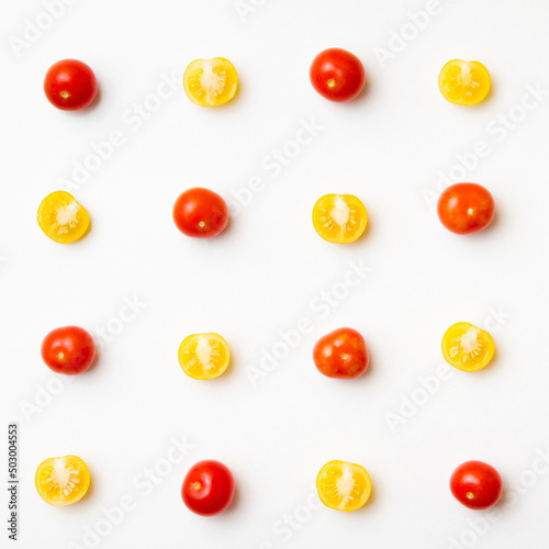 Red and yellow cherry tomatoes pattern on white background. Flat lay. Top view.