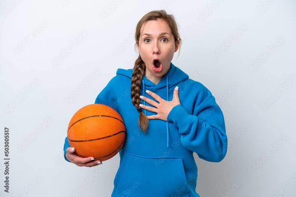 Young caucasian woman playing basketball isolated on white background surprised and shocked while looking right