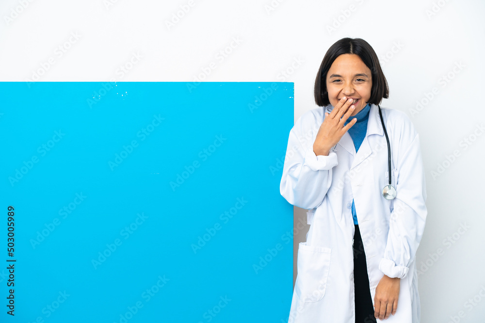 Young mixed race doctor woman with a big placard isolated on white background happy and smiling covering mouth with hand Young mixed race doctor woman with a big placard isolated on white background happy and smiling covering mouth with hand
