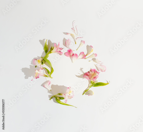 A floral silhouette made of colorful petals and a heart on a white background. Minimal concept of love and affection. Copy space. Flat lay. Creative design.