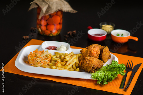 Chicken fried in batter, salad with markovka and french fries, stylized and decorated on a white plate. Arabic cuisine dish. photo