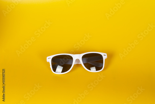 White sunglasses on a yellow background. Hello summer and sunshine
