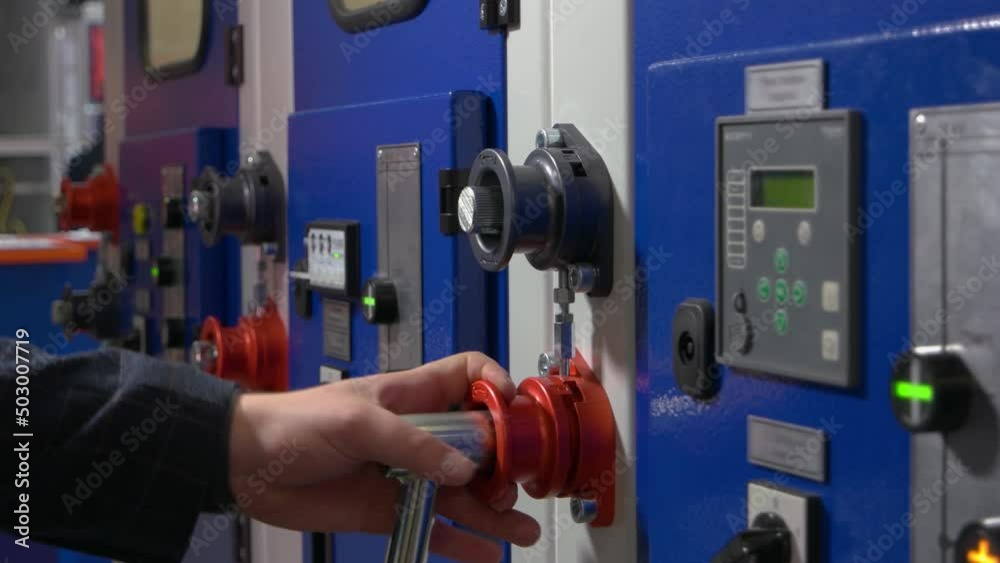 Close-up male hand screwing socket wrench on the machine panel. Plant worker repairing machine element. Close-up male hand screwing socket wrench on the machine panel. Plant worker repairing machine element.