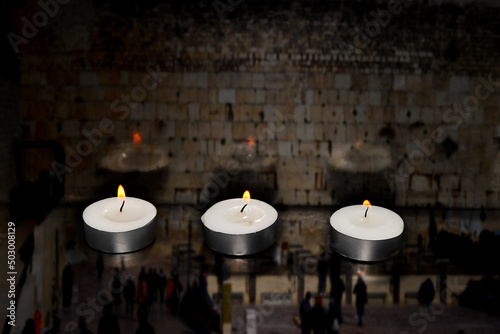 Burning candles on blurred semi transparent Jerusalem Western Wall background. Photo for Israel Memorial Day, Holocaust Remembrance Day or Memorial Day for Fallen Soldiers and Victims of Hostile Acts photo