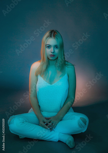 A young girl sits thoughtfully