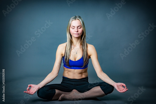 A woman is sitting in a yoga pose