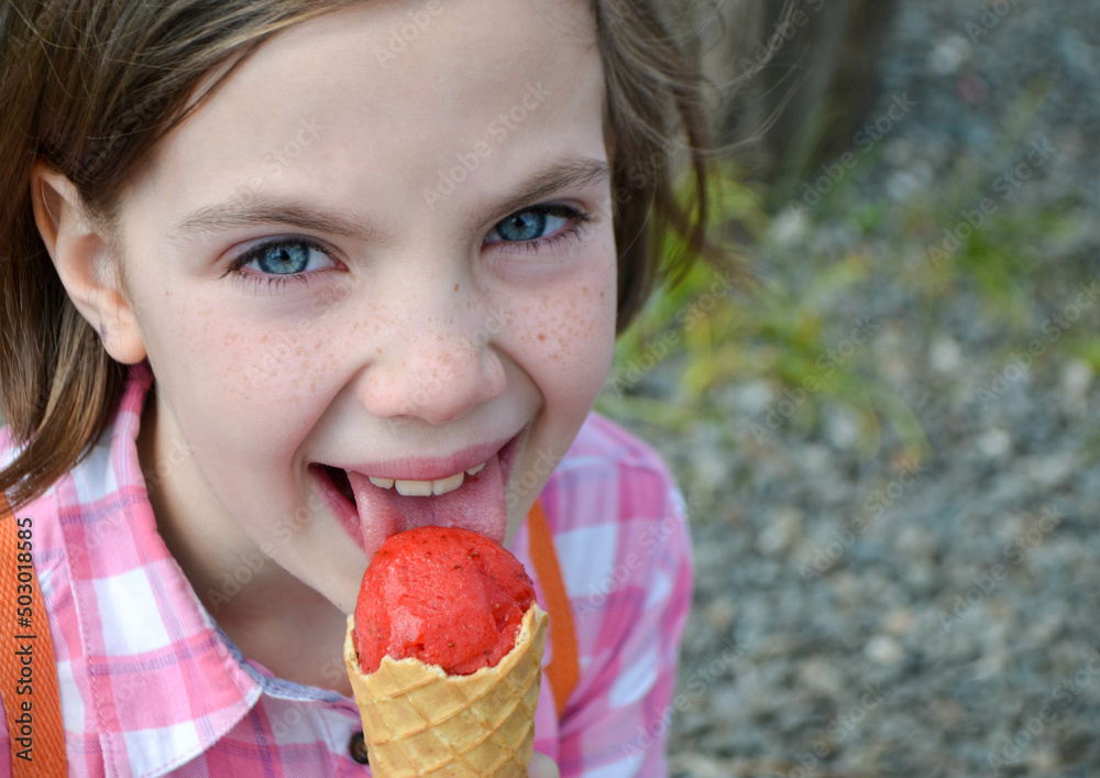 Close up image of girl hand holding fresh waffle cone with vanilla and raspberry ice cream on the wooden background. Walking. Outdoors. High quality photo Close up image of girl hand holding fresh waffle cone with vanilla and raspberry ice cream on the wooden background. Walking. Outdoors. High quality photo
