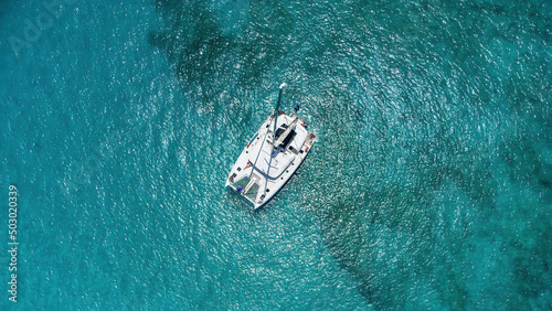 Beautiful sailing catamaran at anchor. Aerial view of a yacht in clear turquoise water in the Indian Ocean. Yachting and travel concept