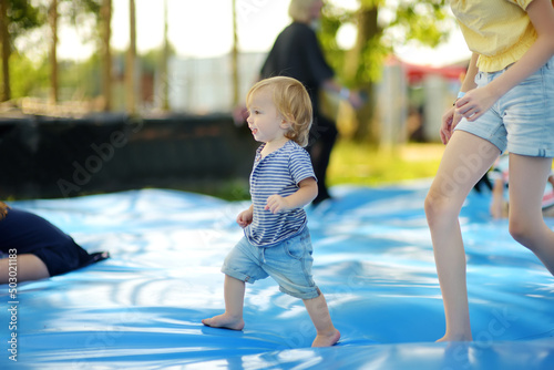 Εκτύπωση καμβά Cute little toddler boy bouncing on huge water filled jumping pillow