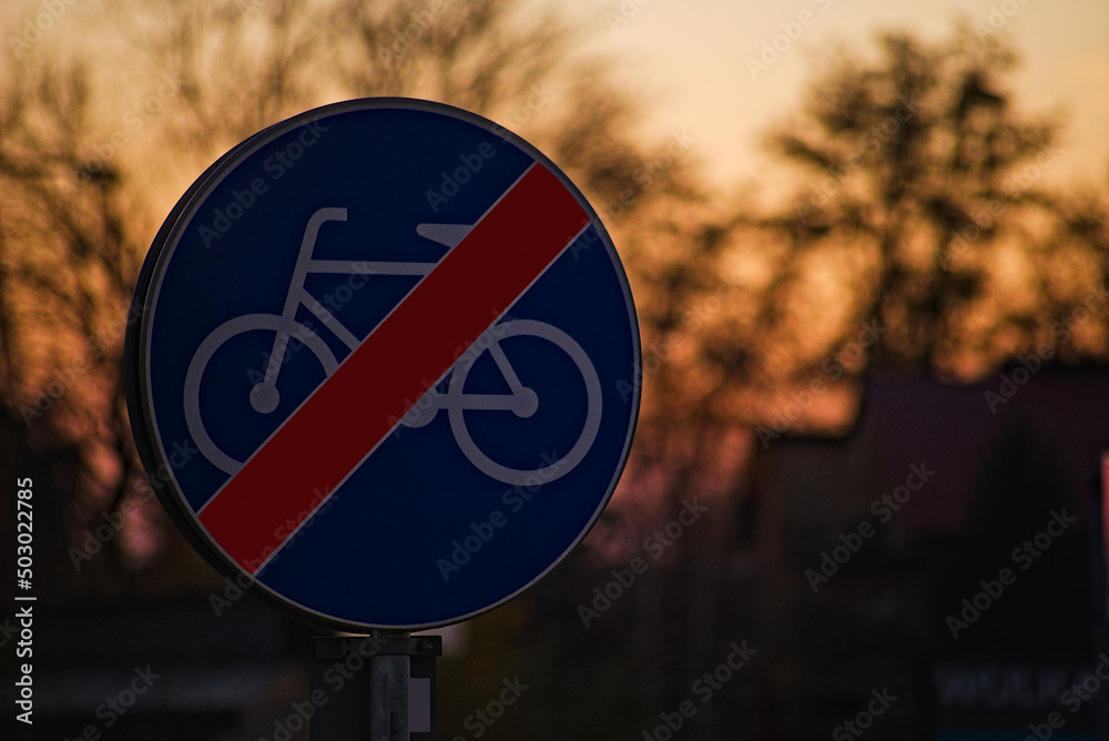 Znak drogowy ; " koniec drogi dla rowerów " , na tle ciemnego nieba podczas zachodu słońca . - obrazy, fototapety, plakaty 