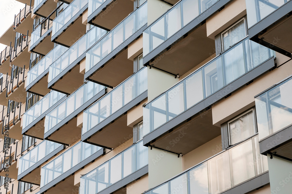 Construction site of modern residential building with glass balcony railings Construction site of modern residential building with glass balcony railings