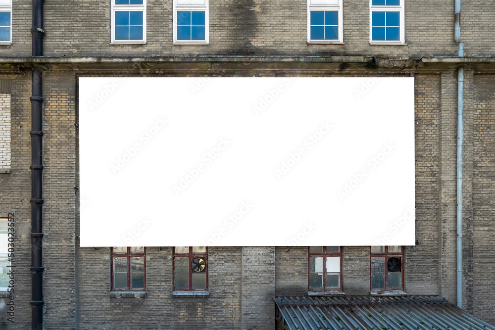 Blank white advertising billboard on the wall of old building