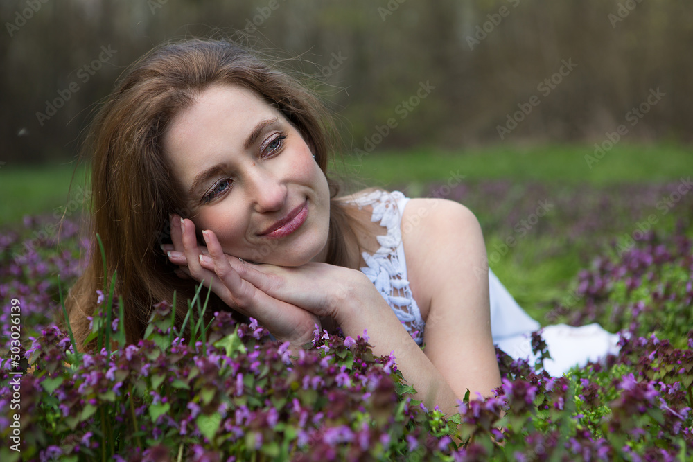 Young relaxed woman enjoys rest lying among wildflowers. Young relaxed woman enjoys rest lying among wildflowers.