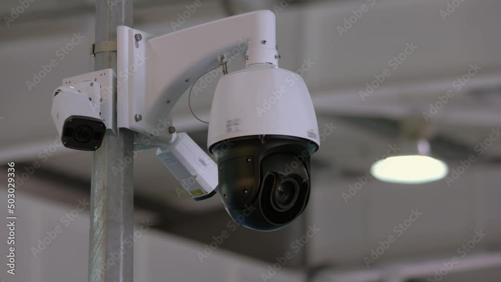 Indoor rotating surveillance camera in the office. Location watch observation.