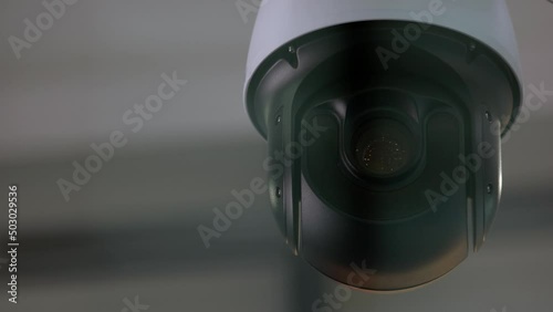 Close-up of surveillance video camera rotating around. Security and safety. photo