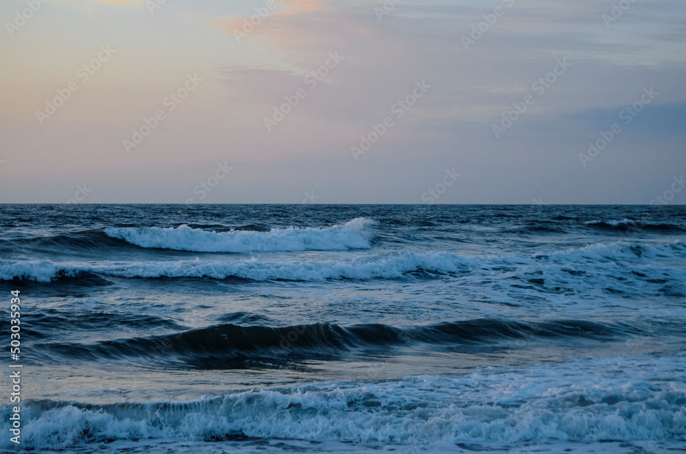 Fototapeta premium Waves washing ashore a sandy beach, Virginia Beach. 